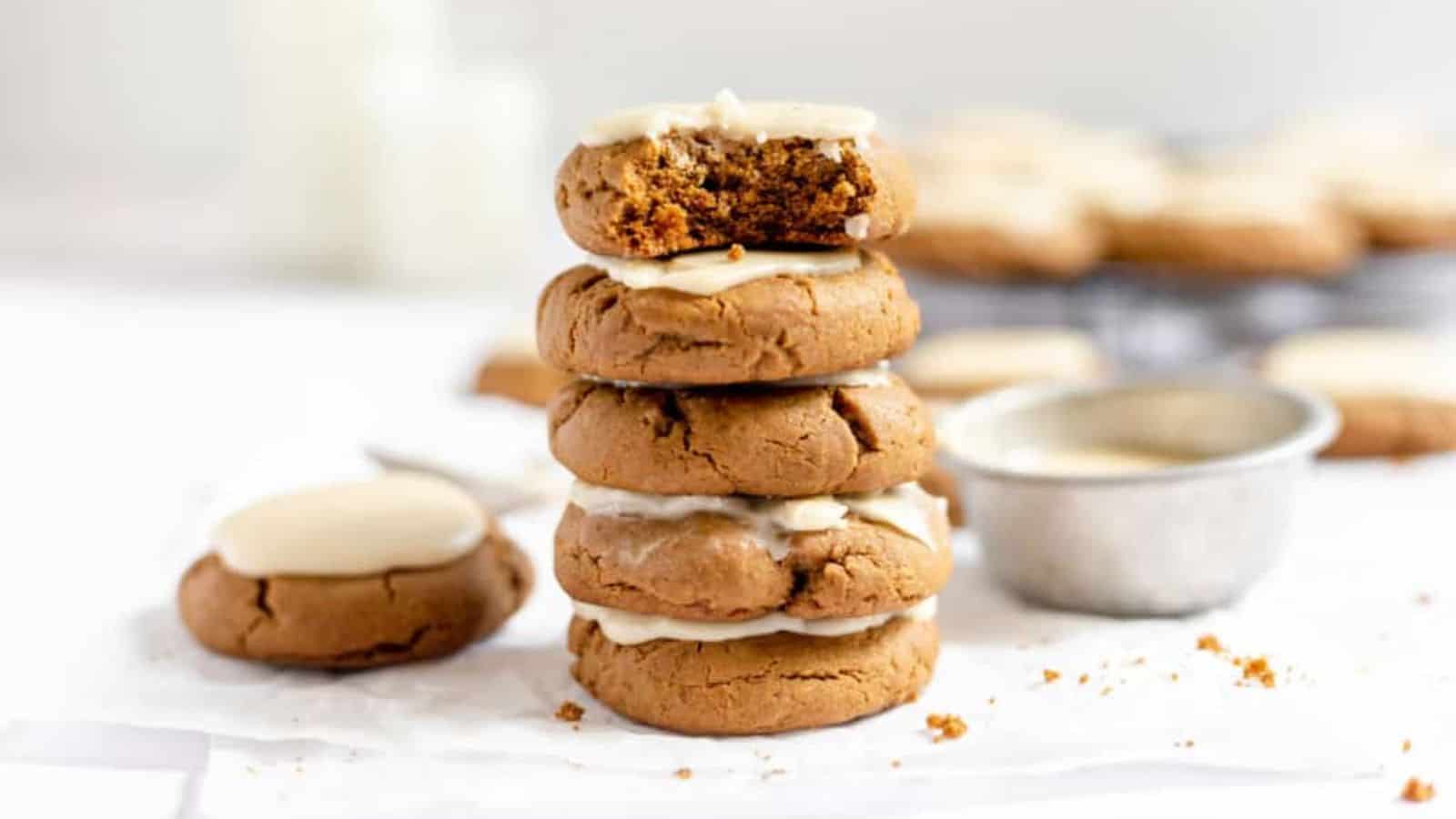 A stack of Iced Molasses Cookies with a bite taken out of them, perfect for winter gatherings or cozy dinners.