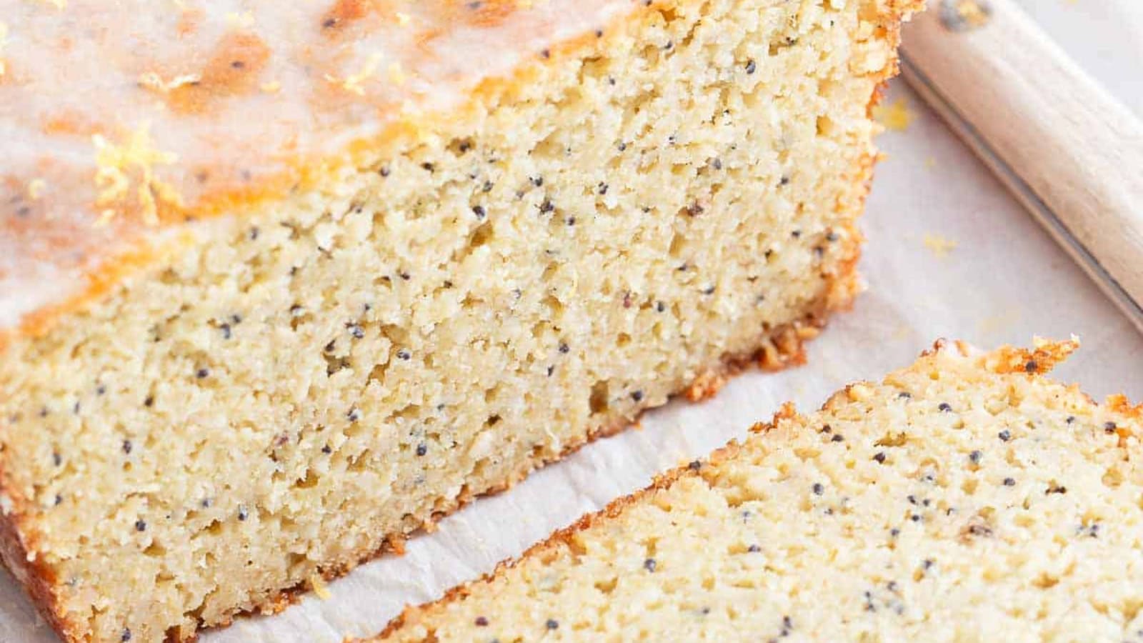 Paleo lemon poppyseed bread slices stacked on top of each other on a plate.