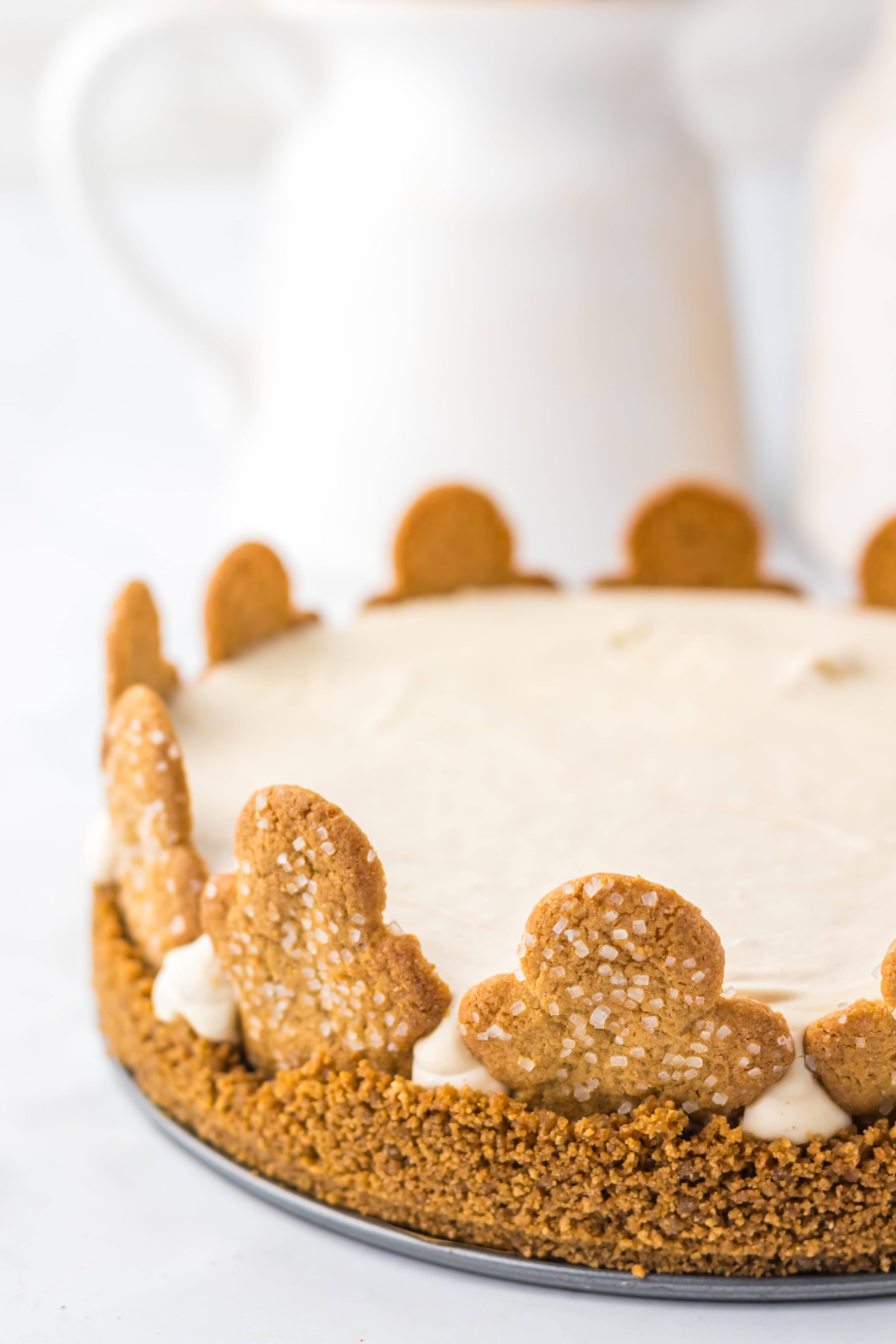 A No Bake Gingerbread Cheesecake with a crumb crust, topped with frosting and decorated with gingerbread cookies around the edge.