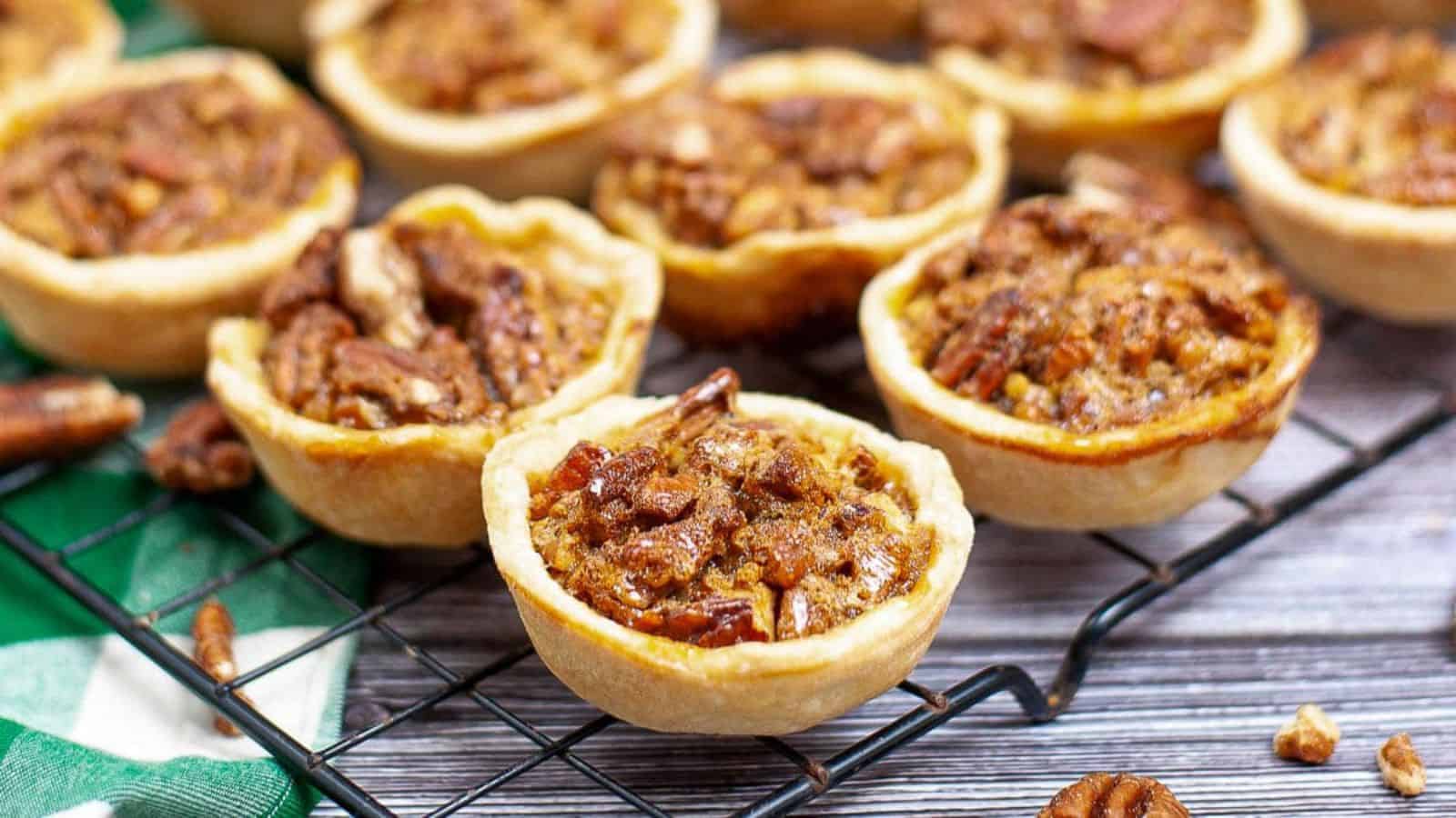 A close-up of mini pecan tassies on a wire cooling rack.