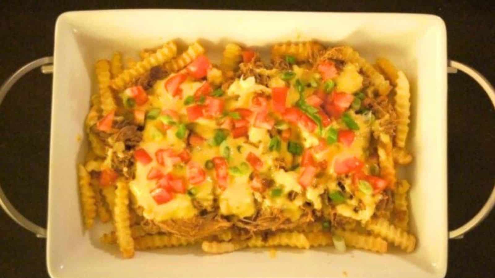 Image shows a white tray filled with Pulled Pork French Fry Nachos.