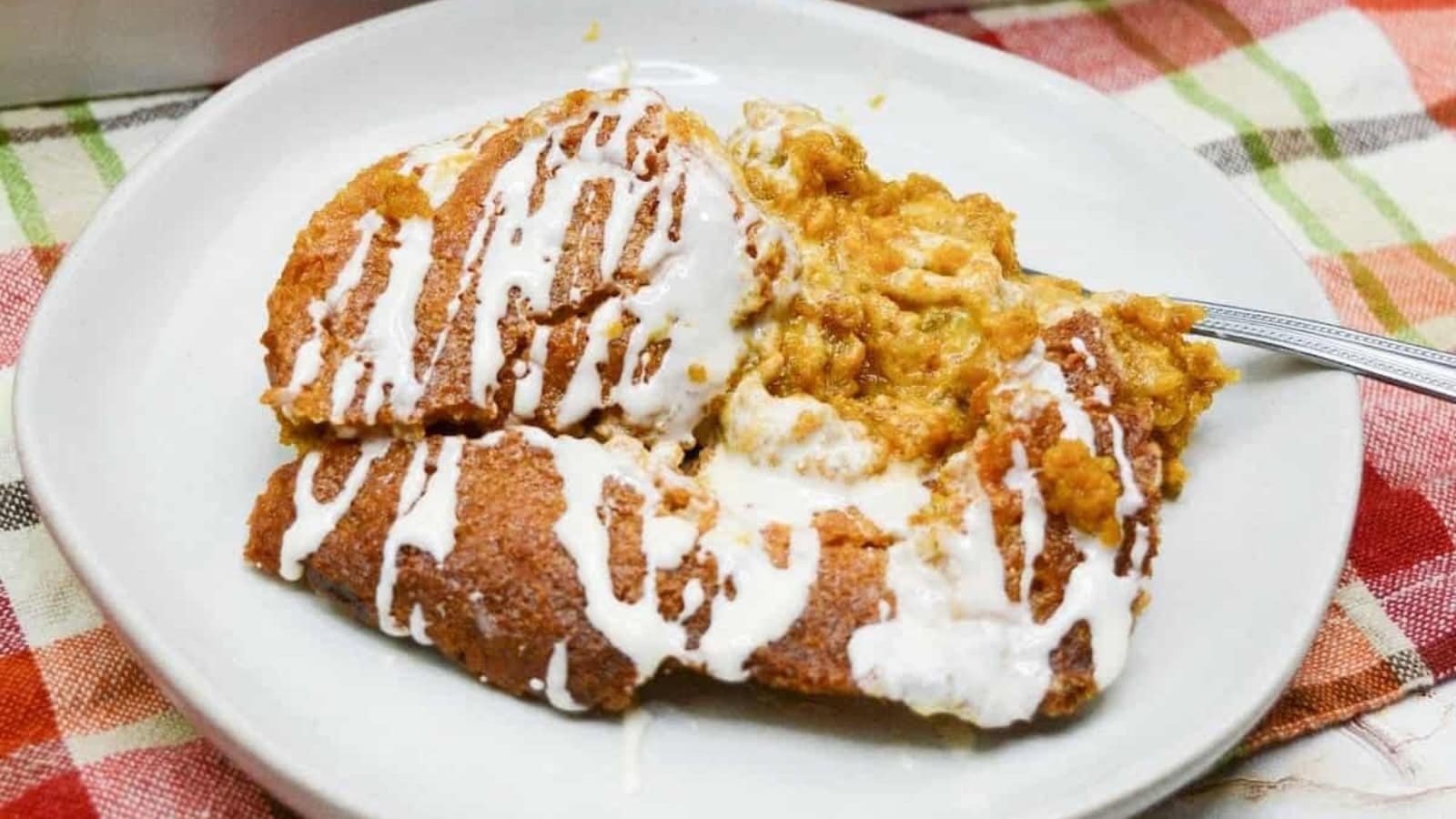 A plate with pumpkin cobbler, resting on a checkered tablecloth.