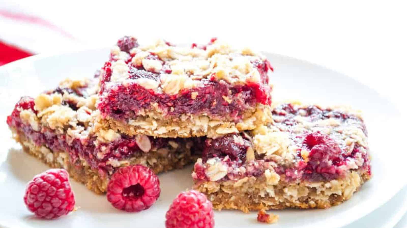 A plate of raspberry bars with sweet rasberry filling.