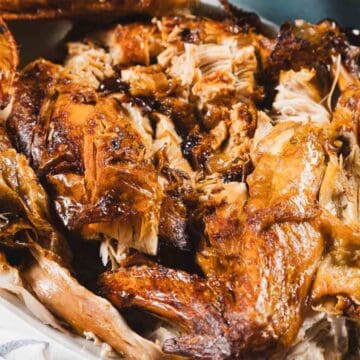Close-up of a platter filled with pieces of roasted turkey, showing crispy golden-brown skin and juicy meat.