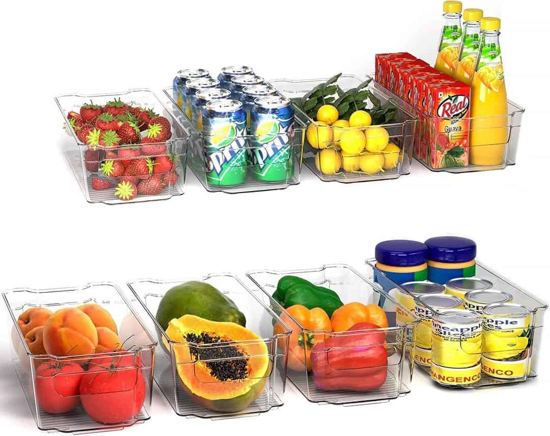 Clear containers holding strawberries, soda cans, juices, lemons, peaches, papaya, bell peppers, and canned goods.