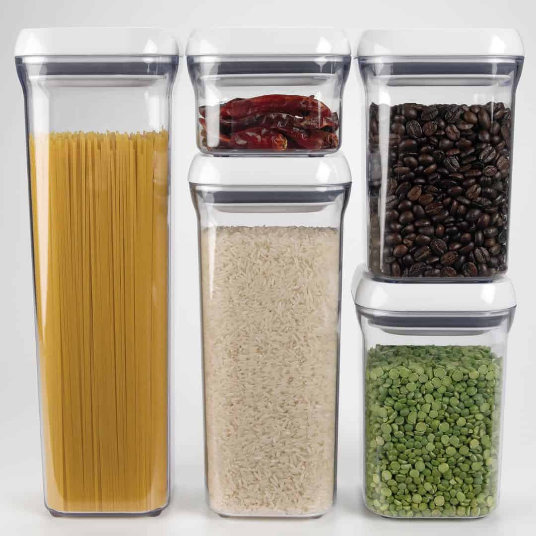 Five clear containers filled with spaghetti, dried chilies, coffee beans, rice, and split peas—perfect food storage gifts for any organized kitchen.