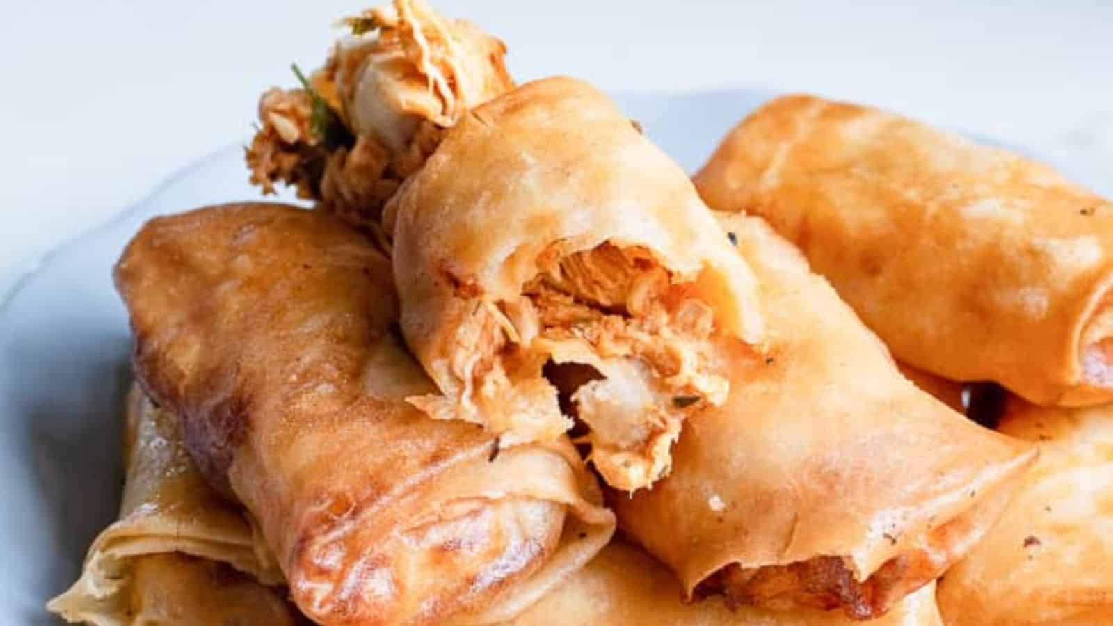 Stack of buffalo chicken egg rolls on a plate.
