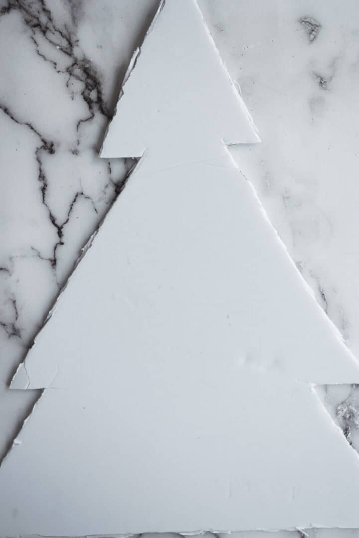 White geometric Christmas tree shape on a marble surface, perfect as inspiration for a modern Christmas Tree Charcuterie Board.