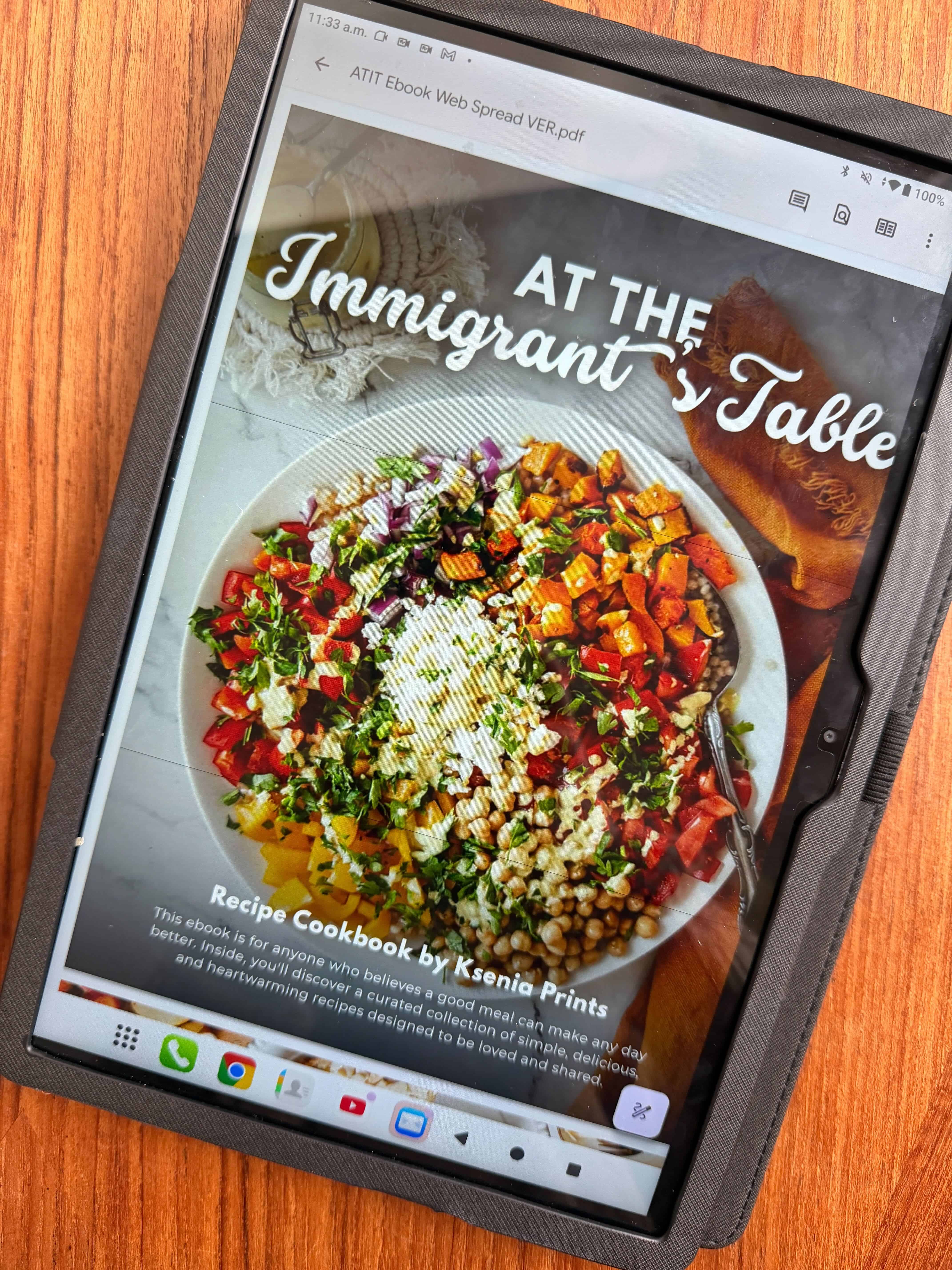 Tablet displaying a colorful salad recipe from the At The Immigrant’s Table E-Book, titled "At The Immigrant's Table".