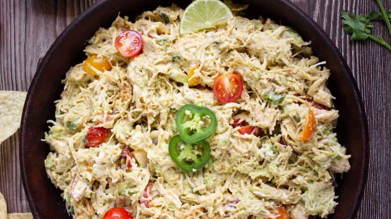 Mexican chicken salad in a bowl with serving spoon.