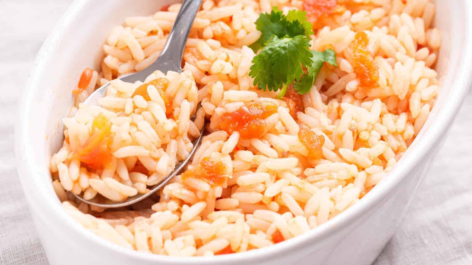 Mexican rice in small oval serving dish with spoon.