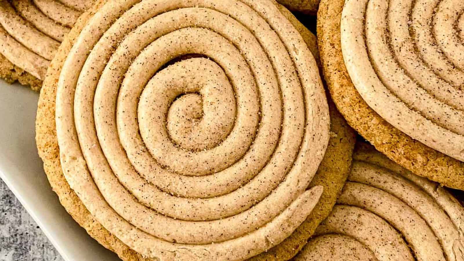 Close-up of spiral cinnamon cookies, stacked on a plate.
