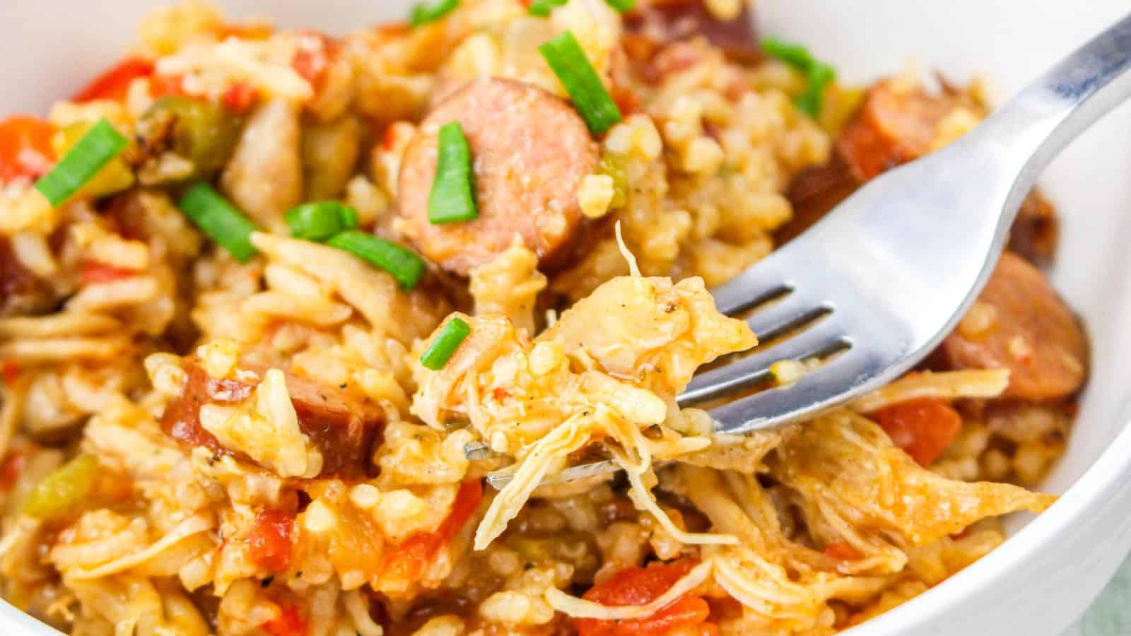 Chicken, sausage, and rice in instant pot with wooden spoon.
