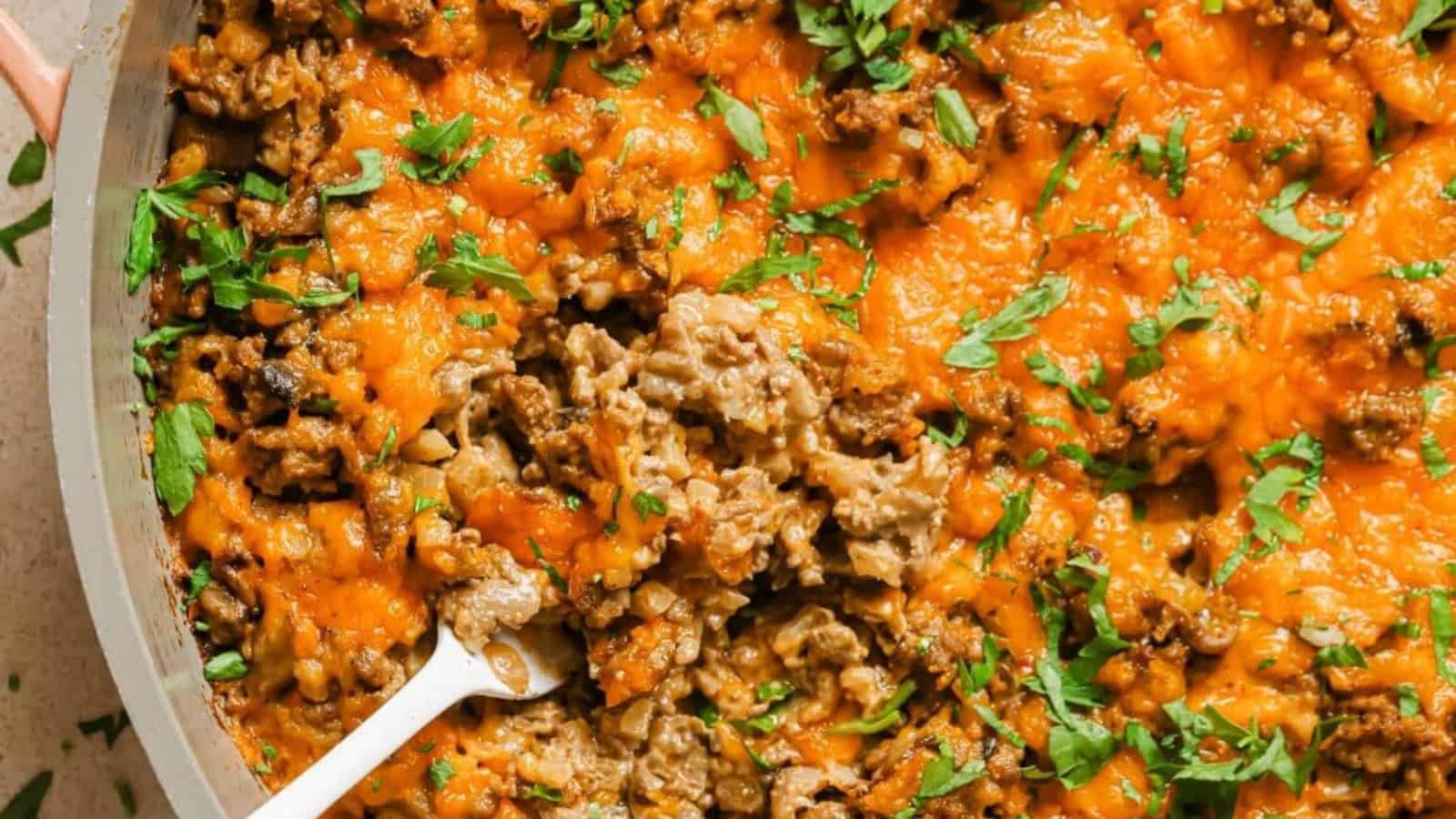 Creamy ground beef skillet with cauliflower rice with a wooden spoon.