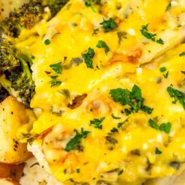 Chicken breast topped with melted cheese and herbs, served with roasted potatoes, broccoli, and mashed potatoes.