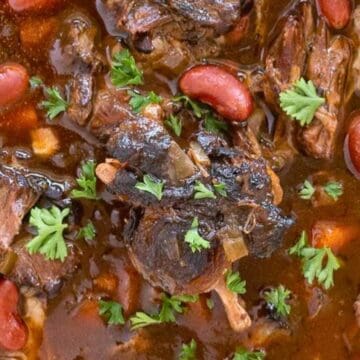 A close-up of beef and kidney bean stew garnished with fresh parsley.