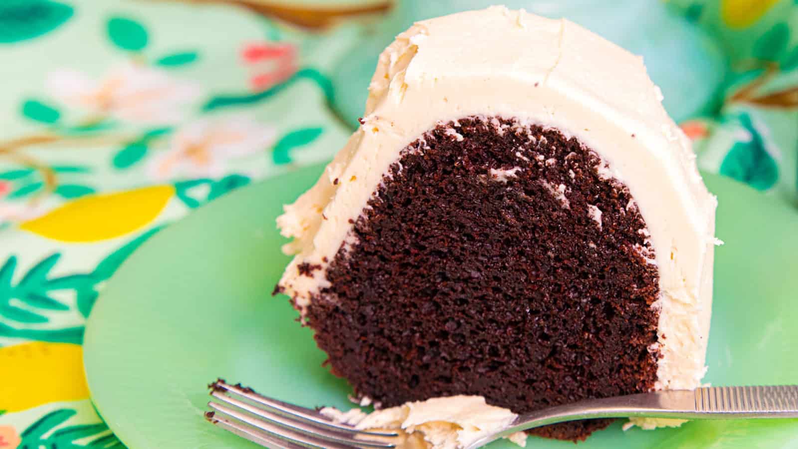 A slice of chocolate cake on a plate with a fork.