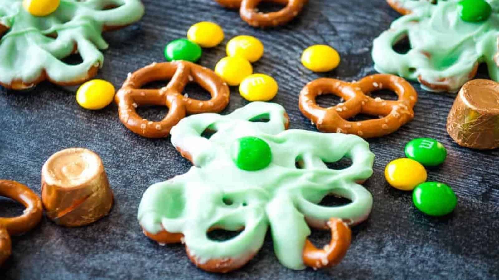 Pretze's assembled to look like clover leaf covered with green colored melted chocolate and M&M's on top.