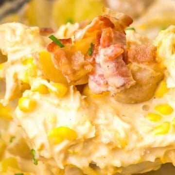 Creamy chicken casserole with corn, potatoes, chopped bacon, and chives in a close-up serving spoon—perfect for cozy Slow Cooker Dinners.