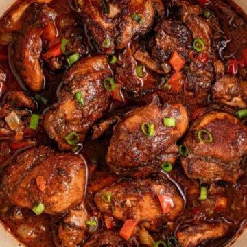 Cooked chicken stew with vegetables and sauce in a white pot, garnished with chopped green onions—an ideal choice for Easy Weeknight Dinners That Work.