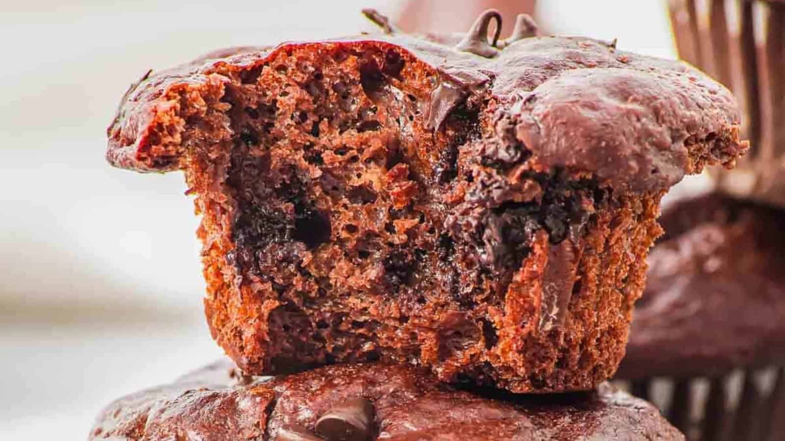 Close-up of a chocolate muffin with a bite taken out, revealing its moist, chocolatey interior and rich chocolate chips—a perfect treat for lovers of Vegetarian Comfort Foods.