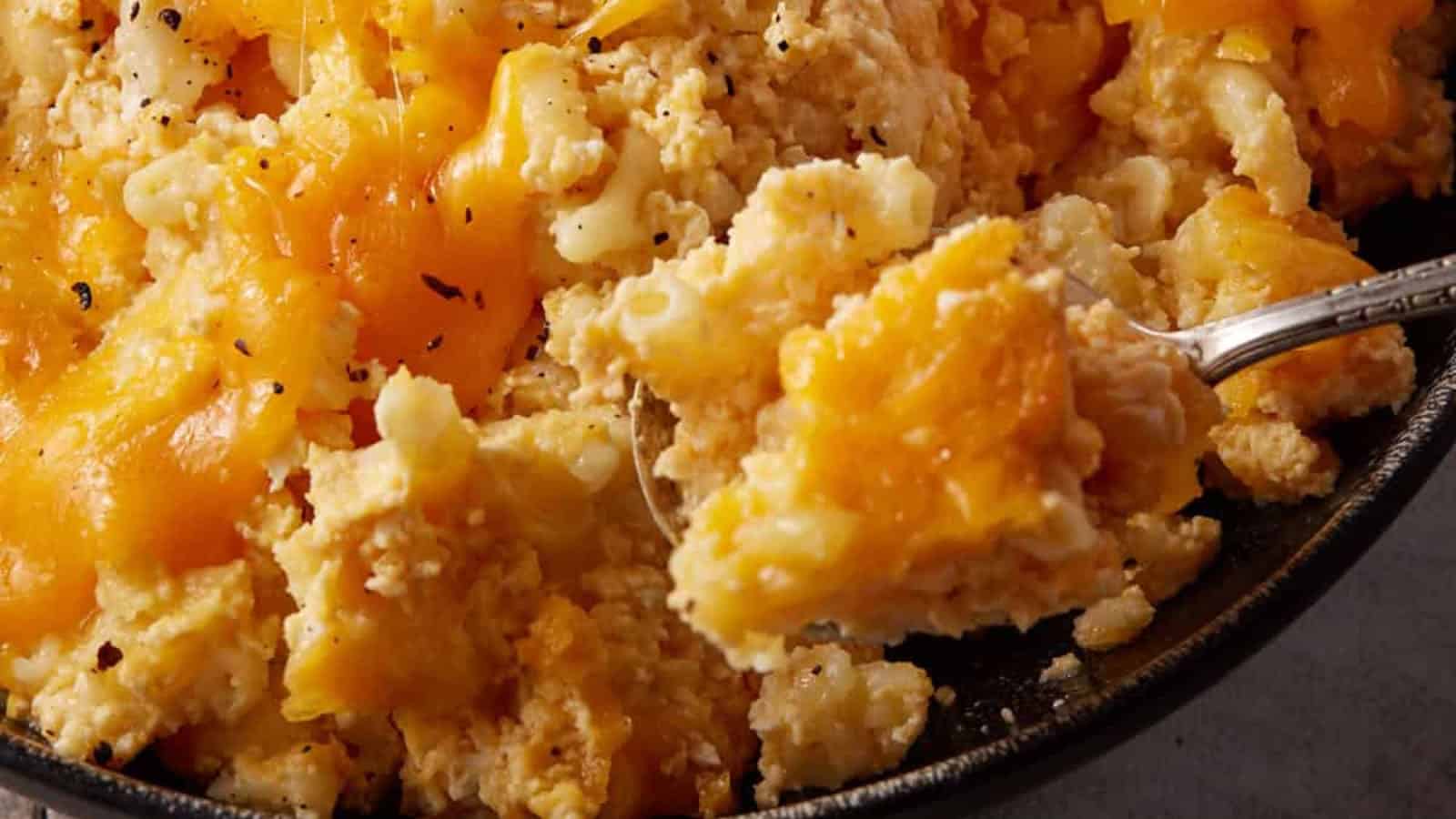 Close-up of creamy baked macaroni and cheese with melted cheddar being scooped with a spoon&mdash;a comforting classic perfect for fans of slow cooker recipes.