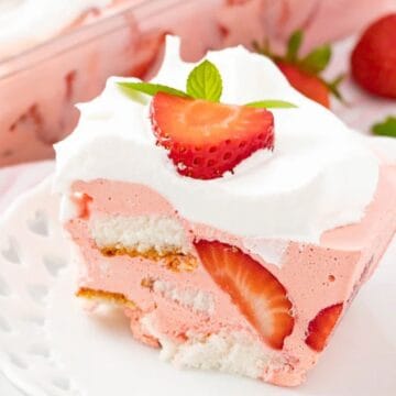 A slice of strawberry shortcake with whipped cream and fresh strawberry garnish on a white plate—one of the easy spring desserts perfect for any occasion.