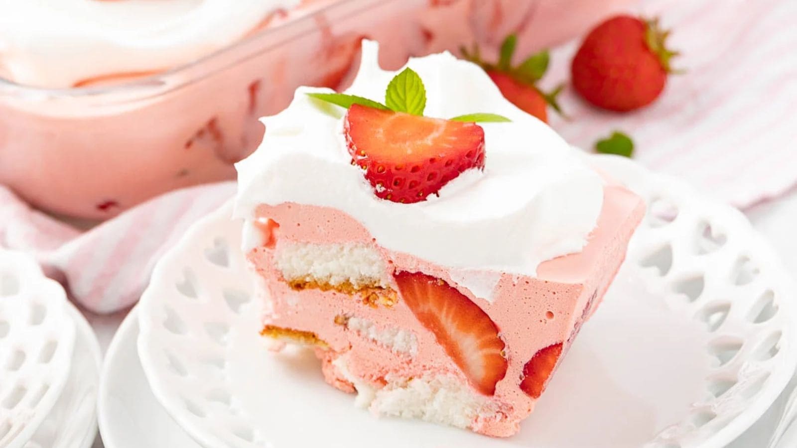 A slice of strawberry shortcake with whipped cream and fresh strawberry garnish on a white plate&mdash;one of the easy spring desserts perfect for any occasion.