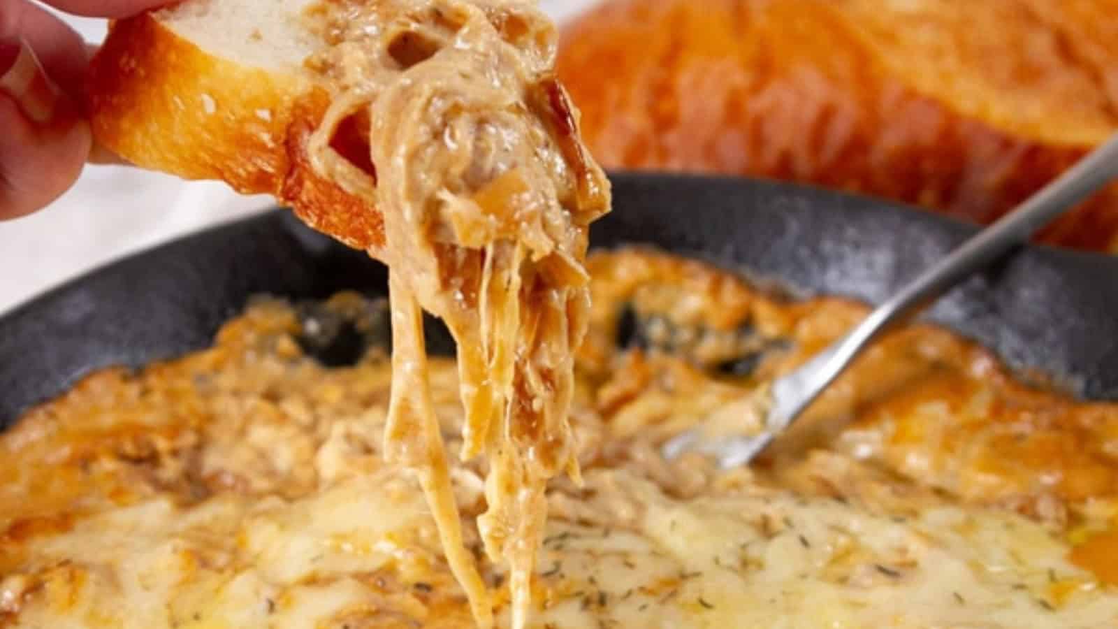 A slice of bread dipped into a hot, cheesy onion dip in a skillet, with cheese stretching between them&mdash;one of those irresistible budget comfort recipes perfect for sharing.