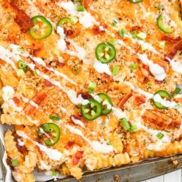 Crinkle-cut fries topped with cheese, bacon, jalapeños, green onions, and drizzled with ranch sauce.