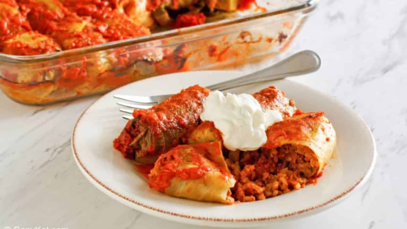 Stuffed cabbage rolls with meat and rice in tomato sauce on a plate.