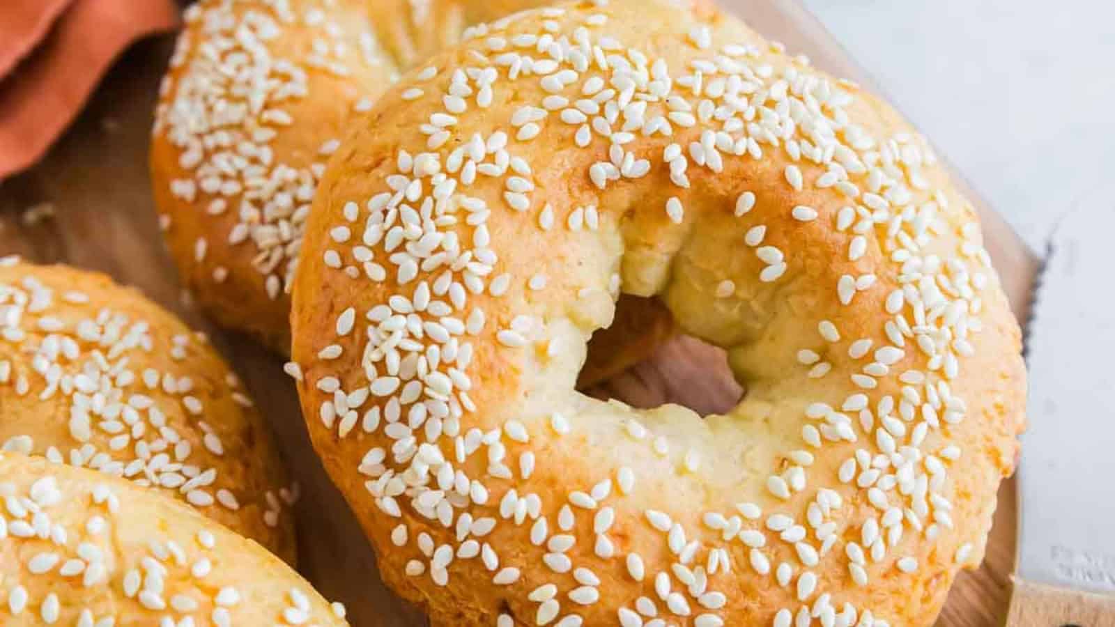 A close-up of sesame seed-covered bagels on a wooden surface, perfect for anyone craving classic Vegetarian Comfort Foods.