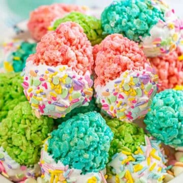 Colorful Rice Krispies treats shaped like scoops, topped with sprinkles and arranged in a bowl.