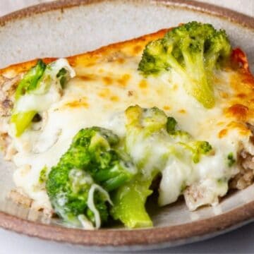 A slice of cheesy broccoli casserole on a beige plate.