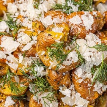 Delicious roasted potatoes garnished with fresh herbs and grated cheese, showcasing immigrant culina.