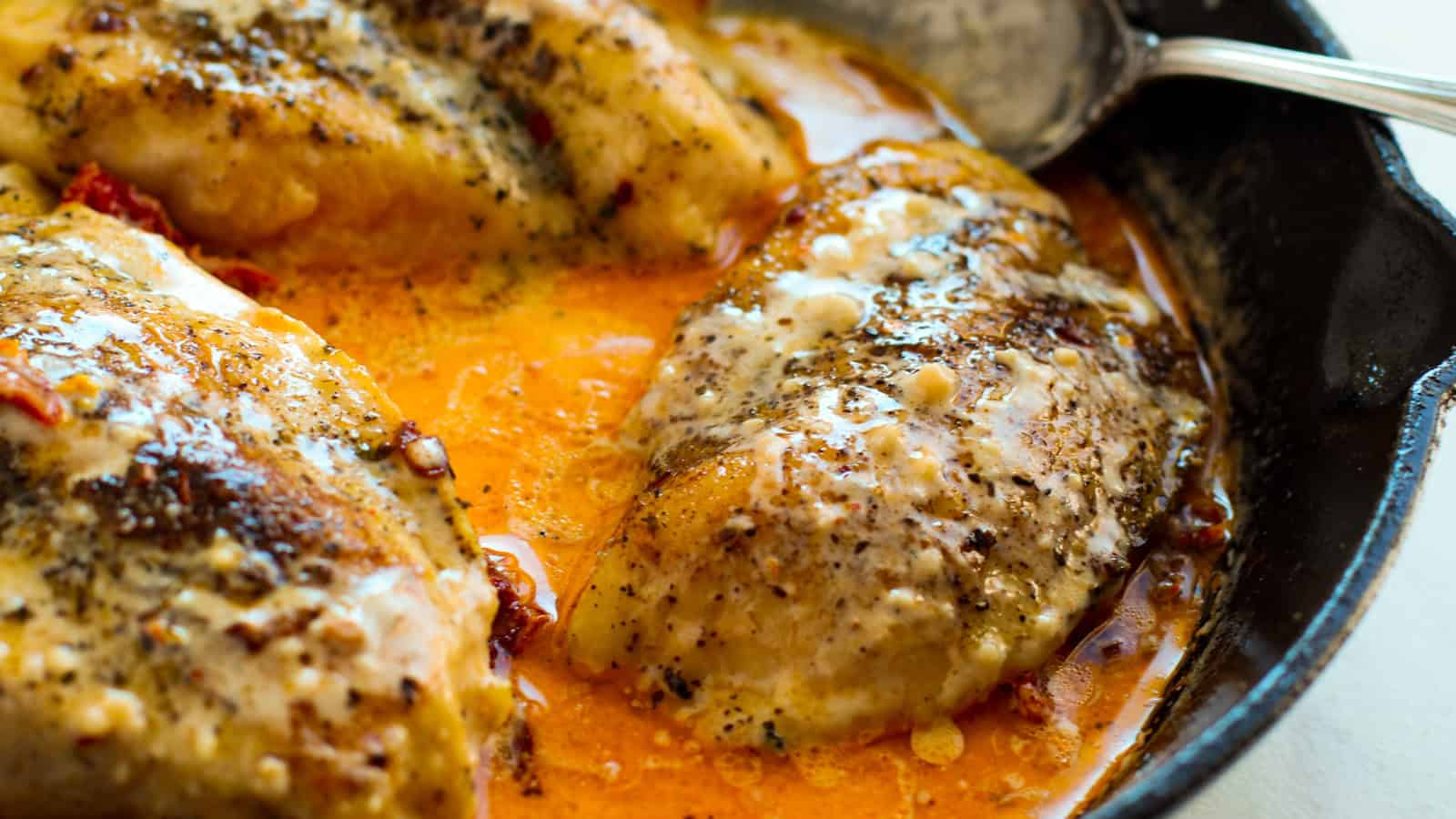 Creamy Marry Me chicken with sun-dried tomatoes in a skillet.