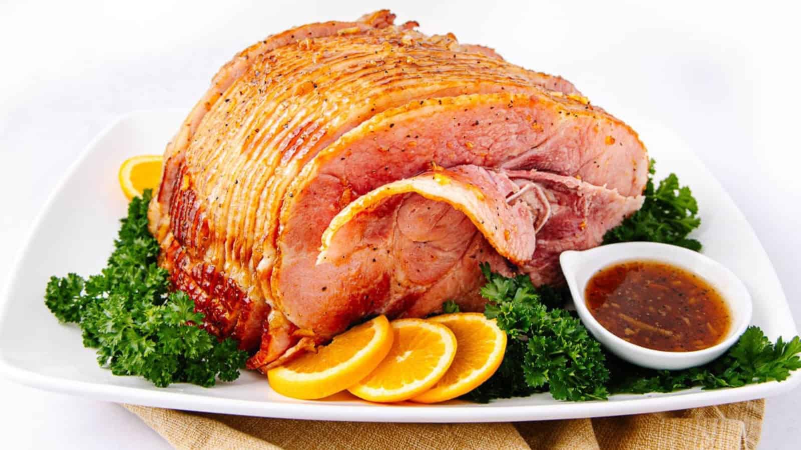 Glazed ham with marmalade coating and sliced presentation.
