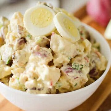 A bowl of creamy potato salad topped with sliced hard-boiled eggs, perfect for spring side dishes.
