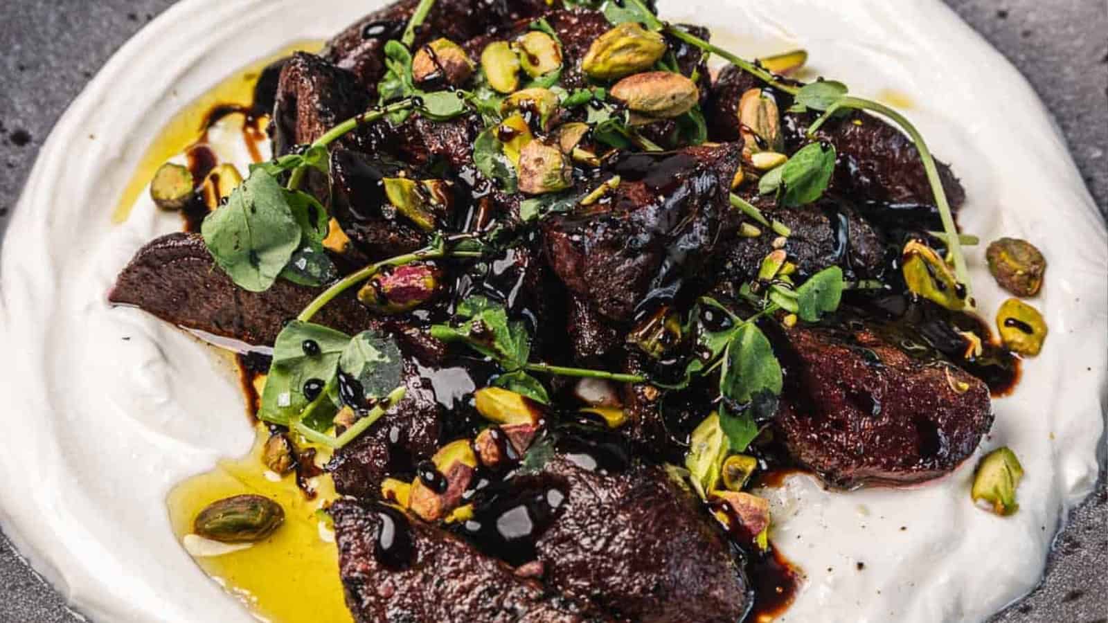 Chicken livers on whipped yogurt, topped with herbs, pistachios, and a drizzle of balsamic glaze.