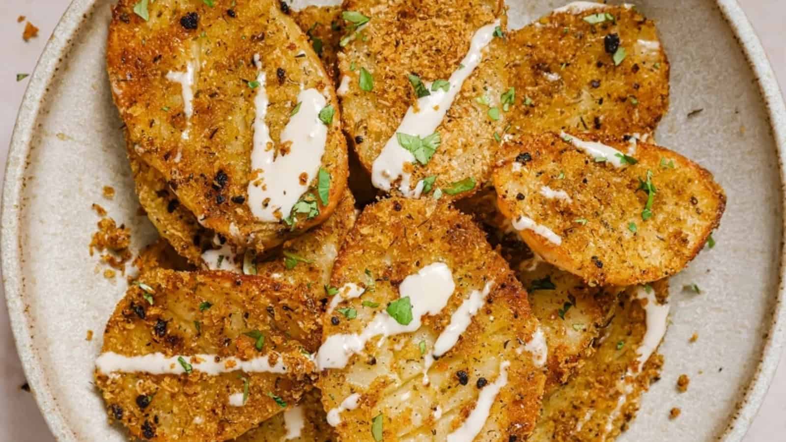 A baking sheet with garnished parmesan crusted potatoes on it.