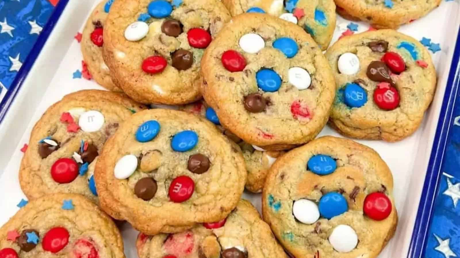 A pile of cookies topped with red, white, and blue candy-coated chocolates on a tray.