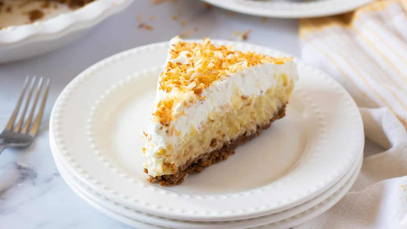 Coconut cream pie with a silky filling topped with whipped cream and coconut flakes.