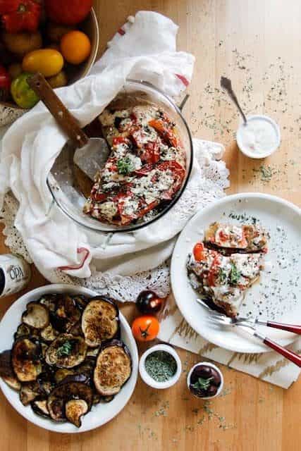 A lightened up version of a classic, this cold moussaka is layered with eggplant, potatoes and tomatoes, and served with tangy kalamata feta sauce.