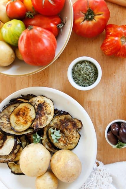 A lightened up version of a classic, this cold moussaka is layered with eggplant, potatoes and tomatoes, and served with tangy kalamata feta sauce.