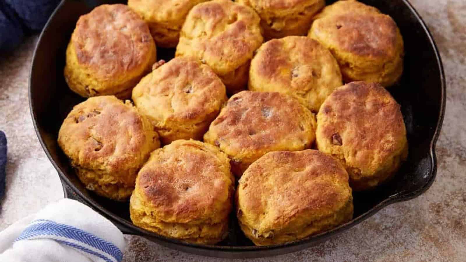 Golden brown biscuits arranged in a black skillet, ready to be served.