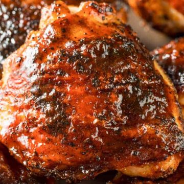 Close-up of juicy grilled chicken thighs with a shiny, caramelized barbecue glaze—perfect for Father's Day BBQ recipes hot off the grill.