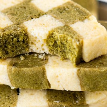 Stack of green and white checkerboard cookies, with bites taken out of the top two cookies.