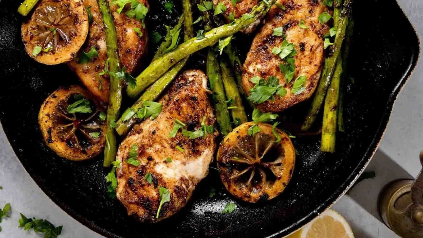 Skillet lemon chicken cooked in a savory sauce with fresh lemon slices and herbs.