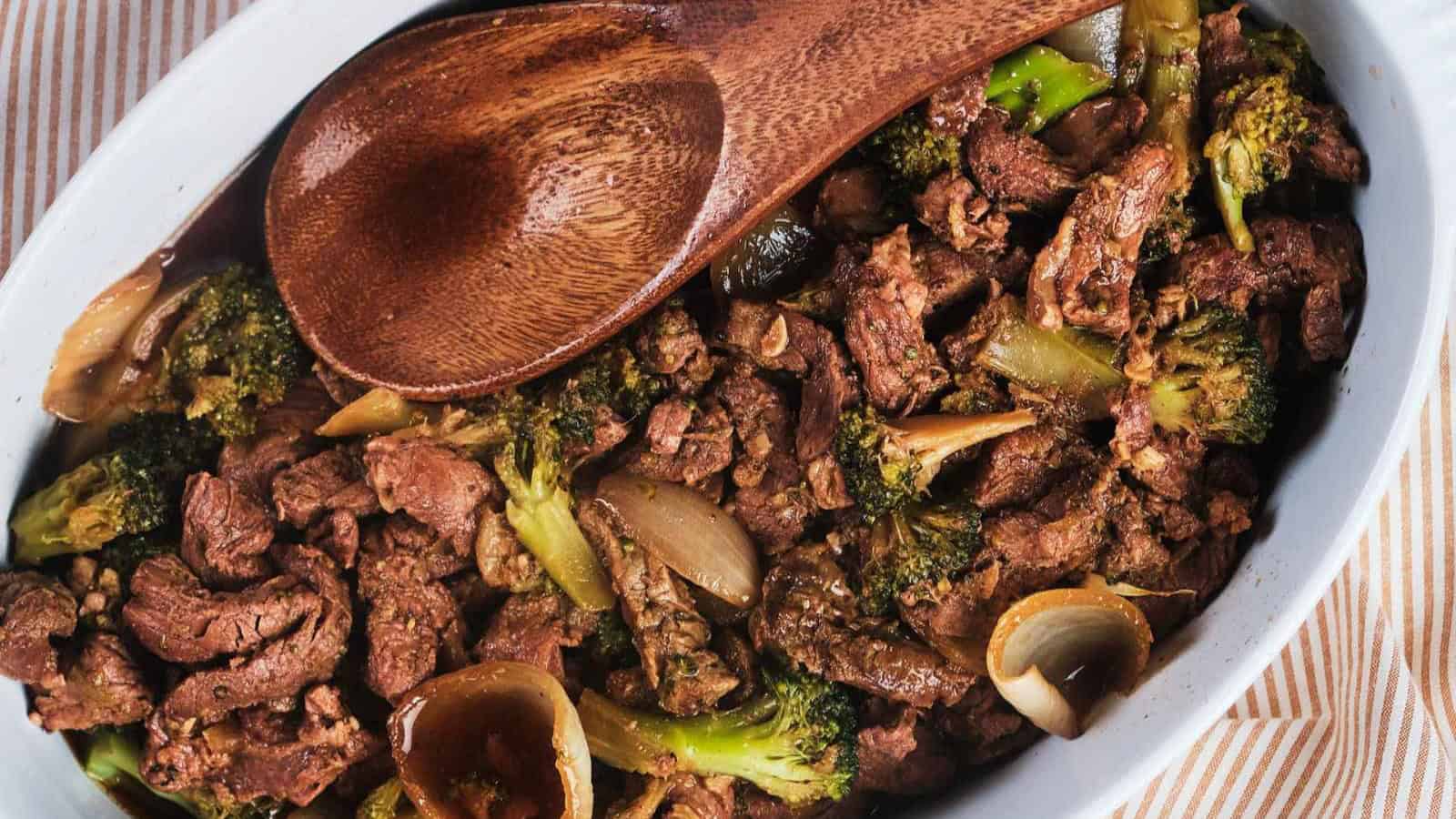 Slow cooker beef and broccoli with onion in brown bowl.