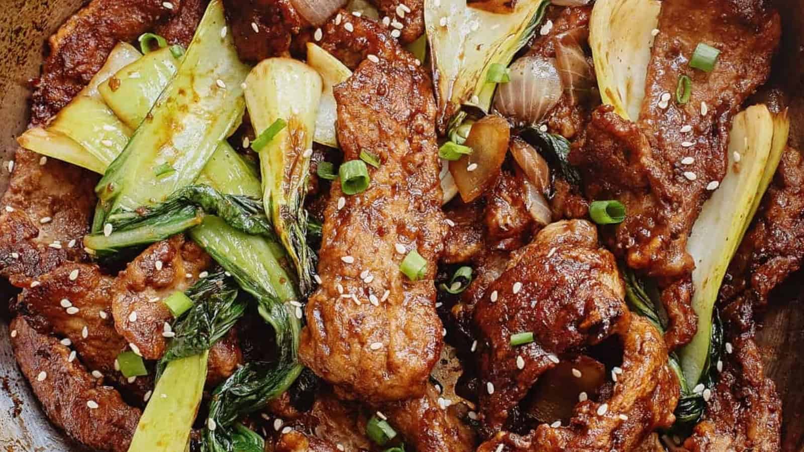 Stir-fried beef with bok choy, onions, green onions, and sesame seeds in a savory sauce.